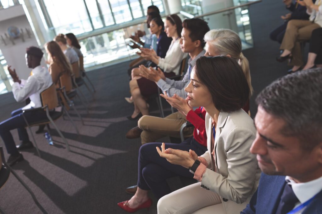 High angle view of diverse business people applauding at a business seminar in office building