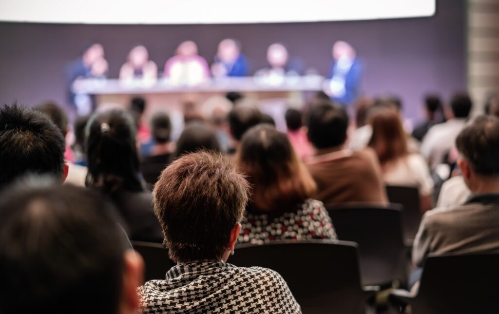 Rear view of Audience in the conference hall or seminar meeting which have Speakers
